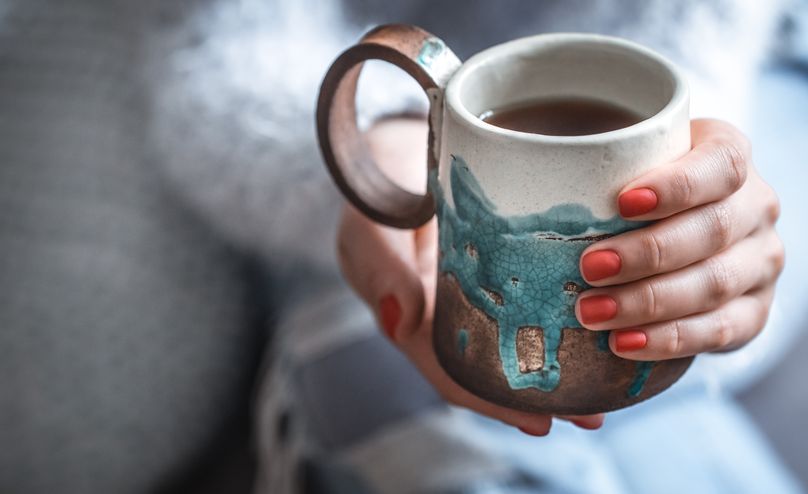 girl holding a cup of tea in hands